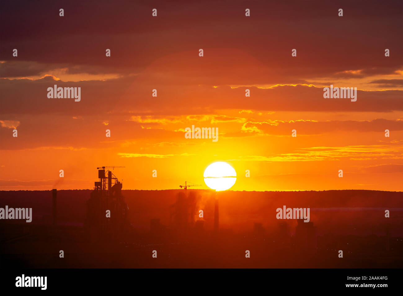 Yellow sunset over industrial landscape with factory chimneys and pipes ...