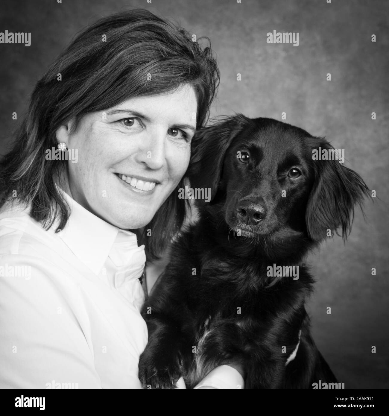 Studio portrait of mature woman with mixed breed dog Stock Photo