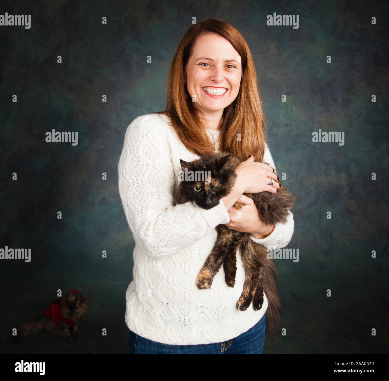 Studio portrait of smiling woman with long haired cat Stock Photo