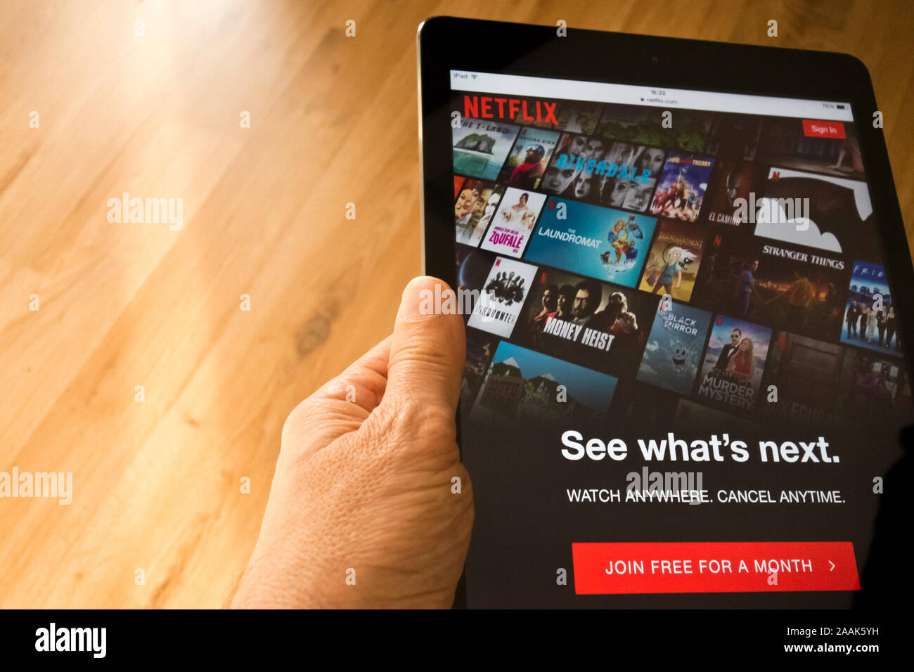 hand holding a tablet with Netflix homepage on the screen Stock Photo