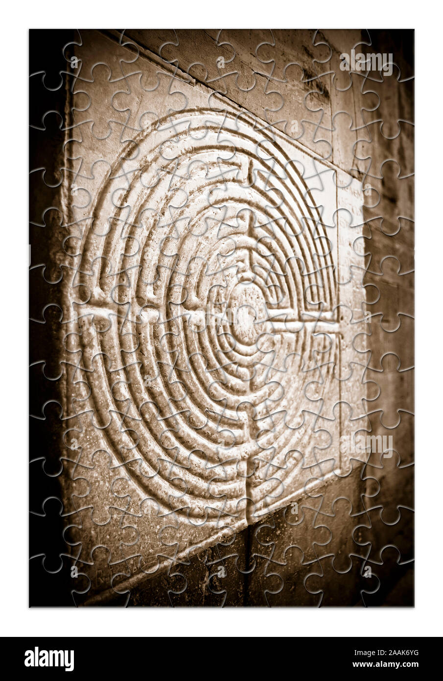 Labyrinth carved on the facade of a Romanesque church of the 11th century - concept image in jigsaw puzzle shape Stock Photo