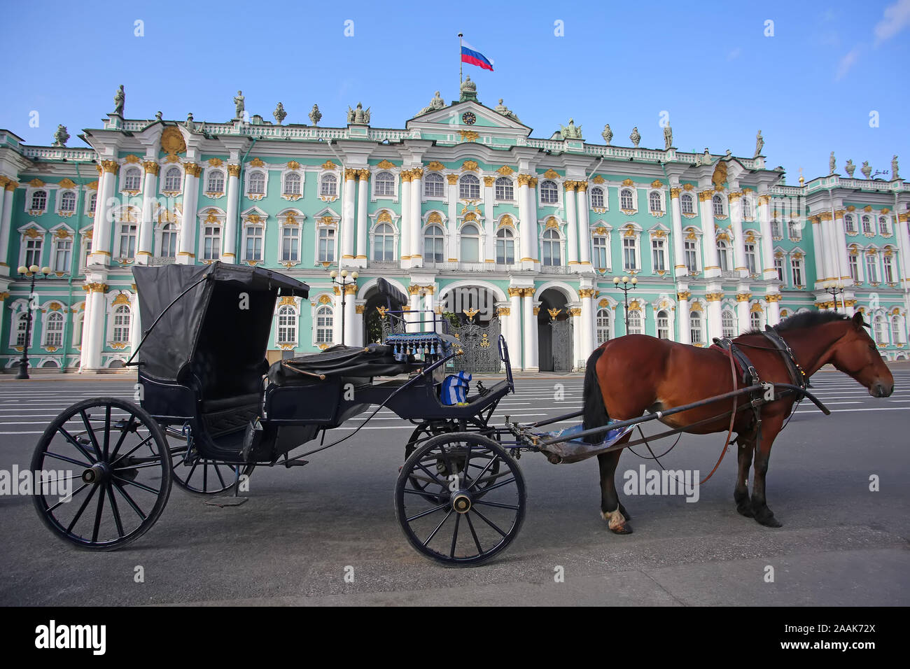 A horse & carriage waiting in Palace Square, which is the central square, and the Hermitage museum or Winter Palace in the background, St Petersburg, Stock Photo