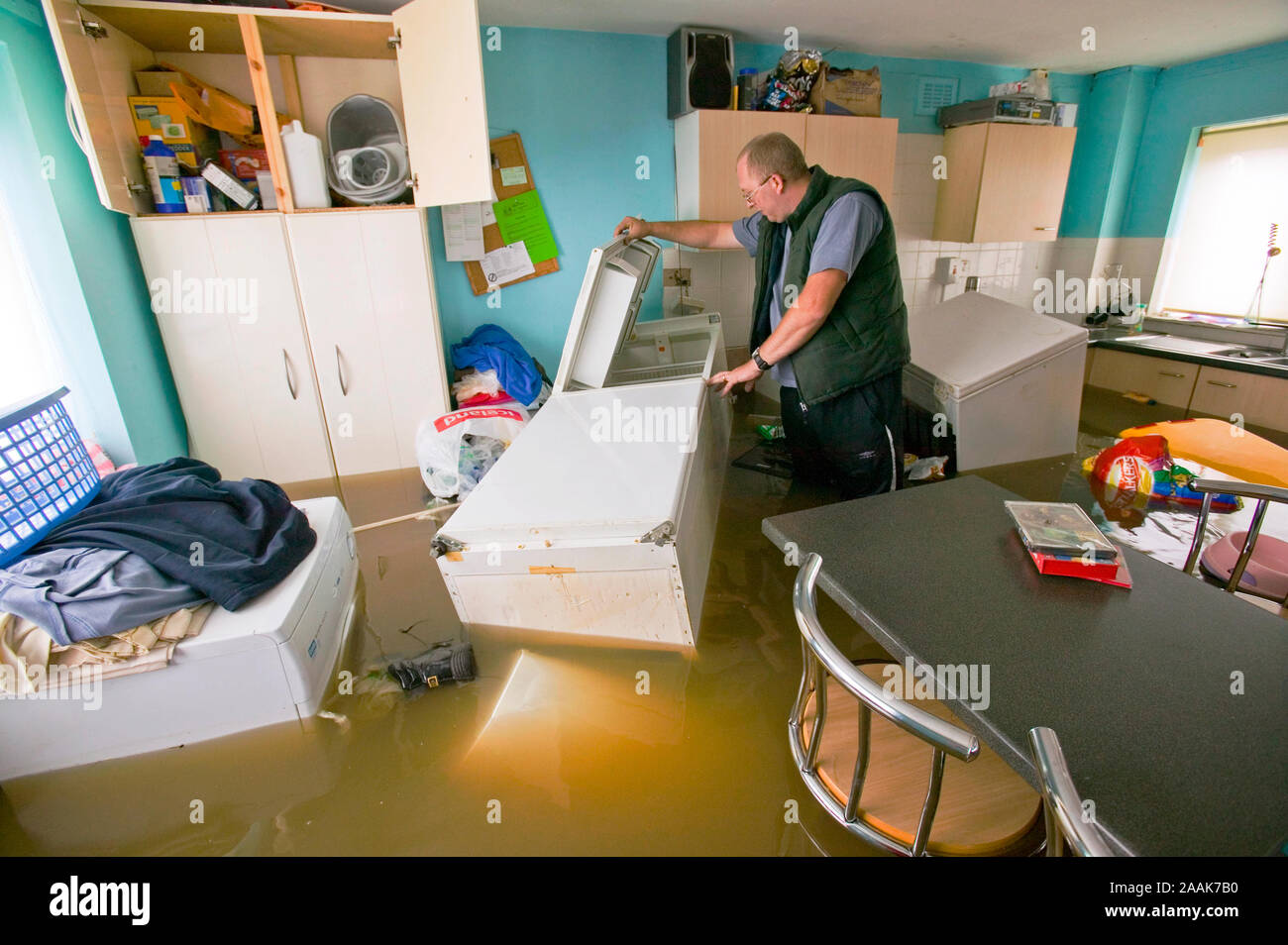 A marooned resident searches for food Inside a flooded house in Toll Bar, South Yorkshire,UK hit by unprecedented floods during June 2007. The village Stock Photo