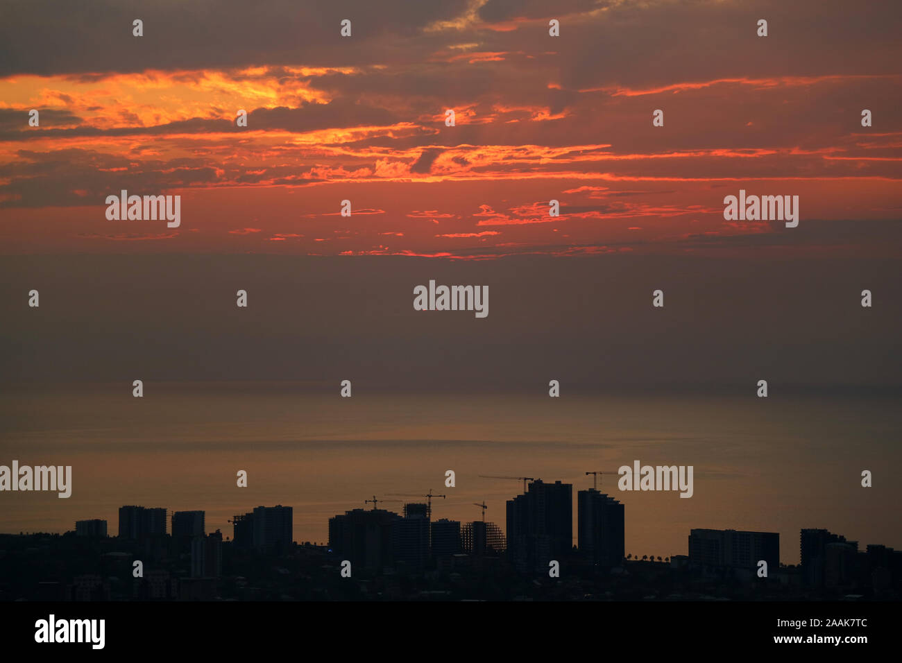 Silhouette of skyscrapers and construction area with sunset sky over ...