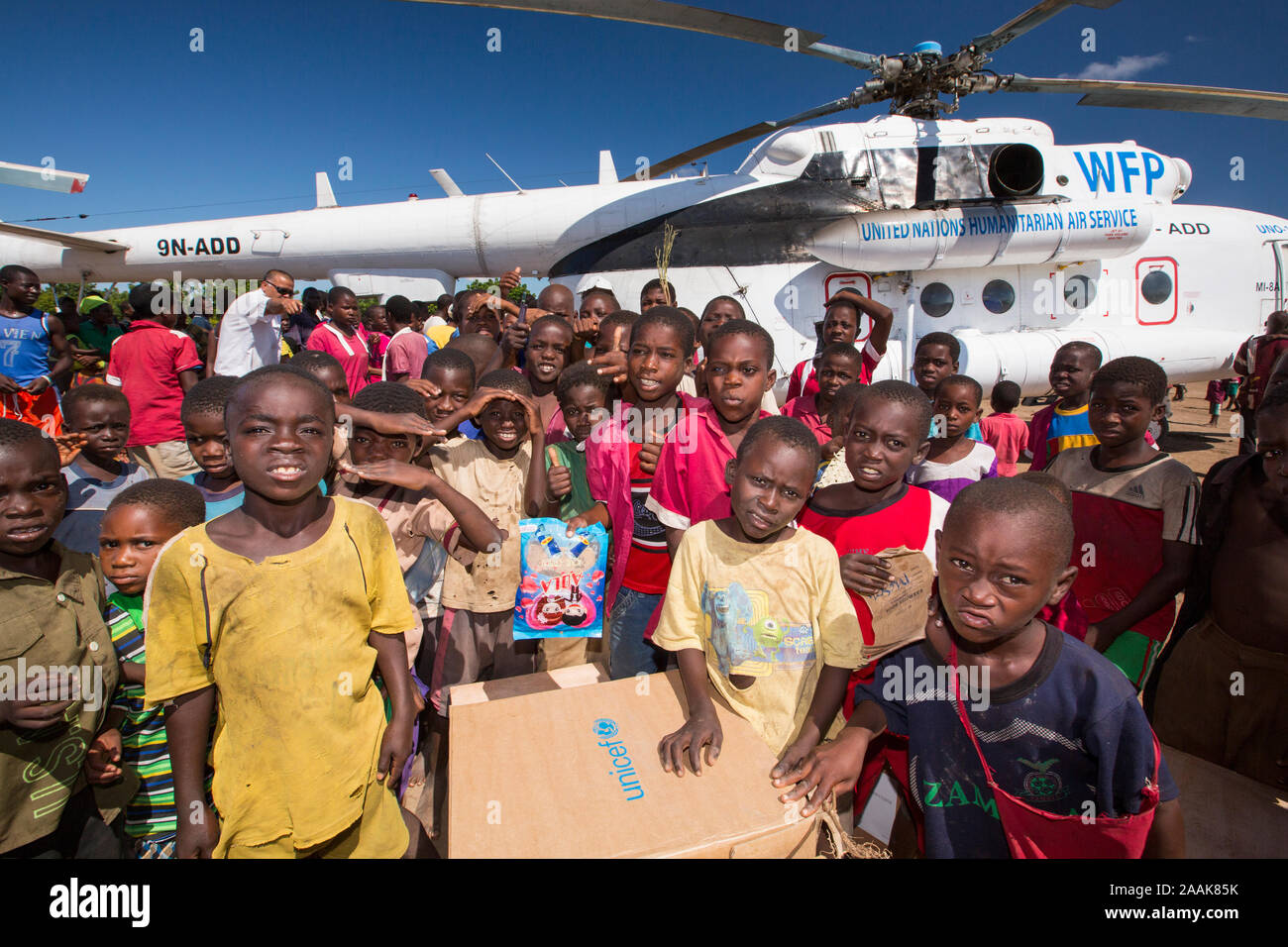 Children crowd around a Russian Mi8 helicopter being used by the United Nations, World Food Program to deliver food aid to areas still cut off by the Stock Photo