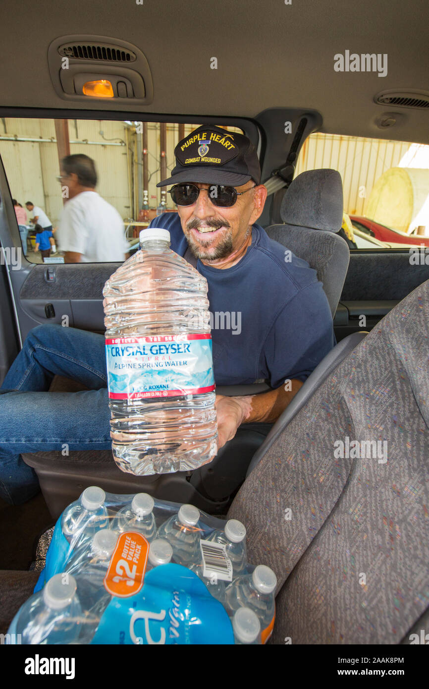 A war veteran collects water from a charity in Porterville supplying bottled water to houses who have had no running water for over five months in Cal Stock Photo