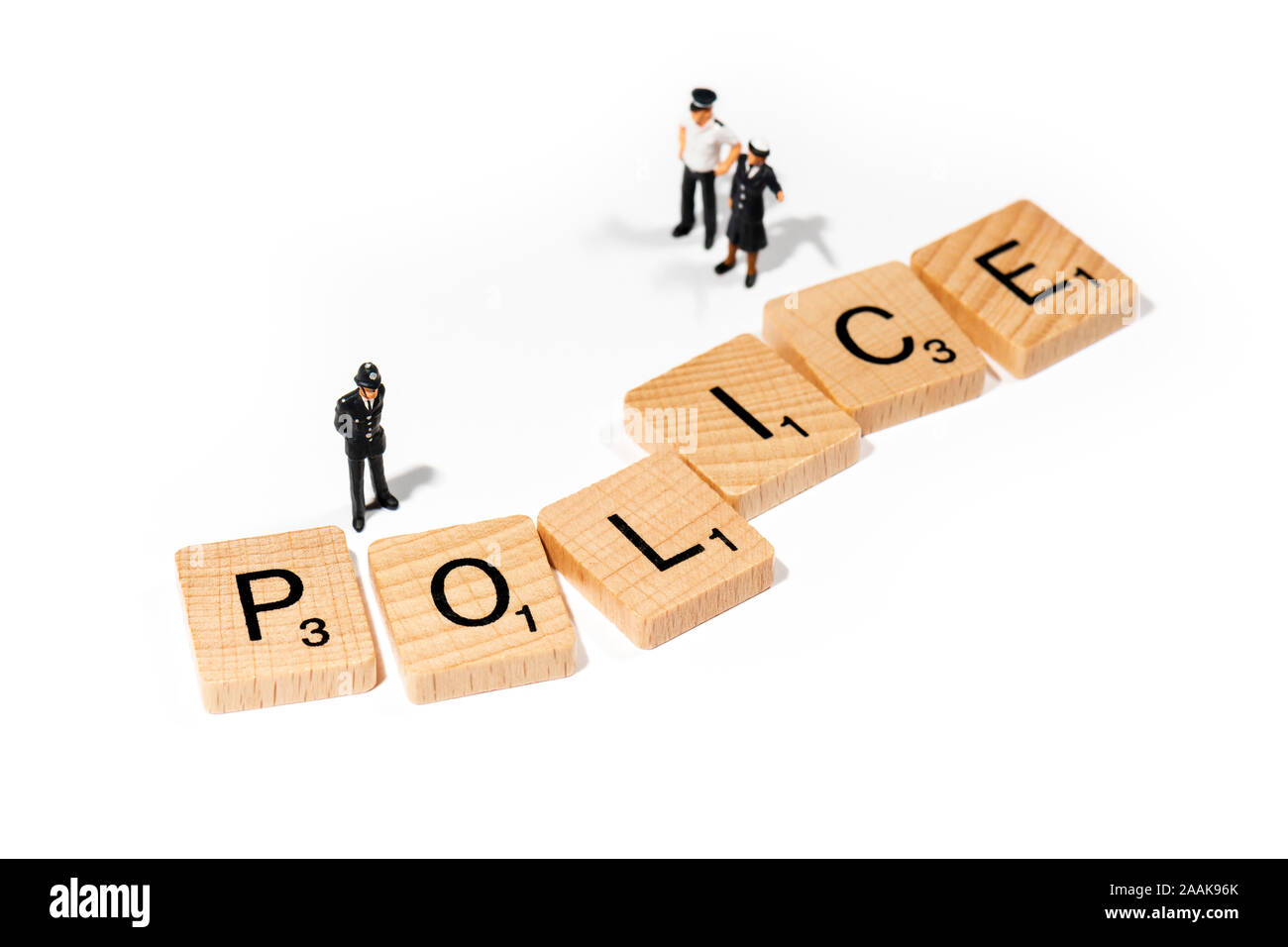 Conceptual: Scrabble letters spell out POLICE , accompanied by  model police officer figurines. Stock Photo
