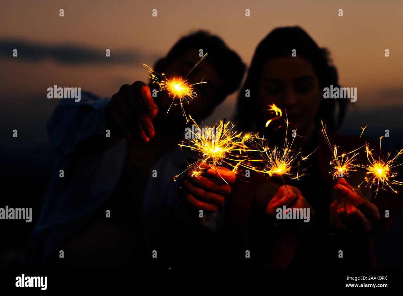 Bengal fire sticks, sparkling, burning, elegant classy ladie and gentlemen hands holding fire-sticks together Stock Photo