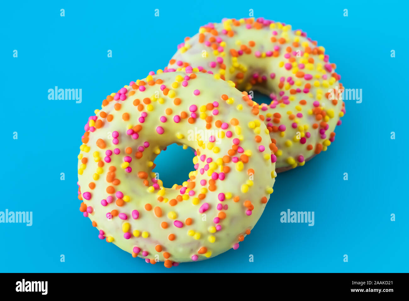 Glazed donuts on blue background. Round donut with a hole. Funny mood concept. Modern food design. Stock Photo