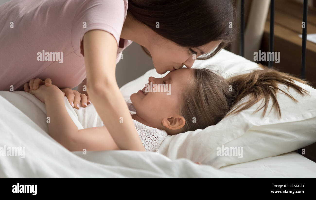 Loving mom kiss little daughter wishing her good night Stock Photo ...