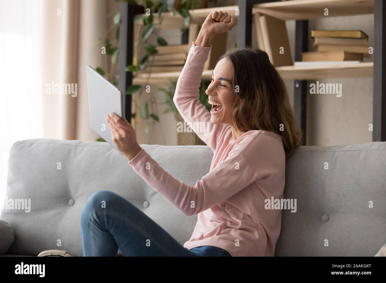 Overjoyed woman feel euphoric getting good message on tablet Stock Photo