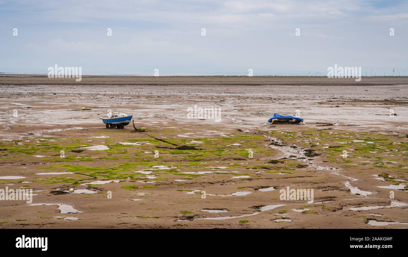 Two boats in the mud of the Walney Channel, seen from the road to Roa Island, Cumbria, England, UK Stock Photo