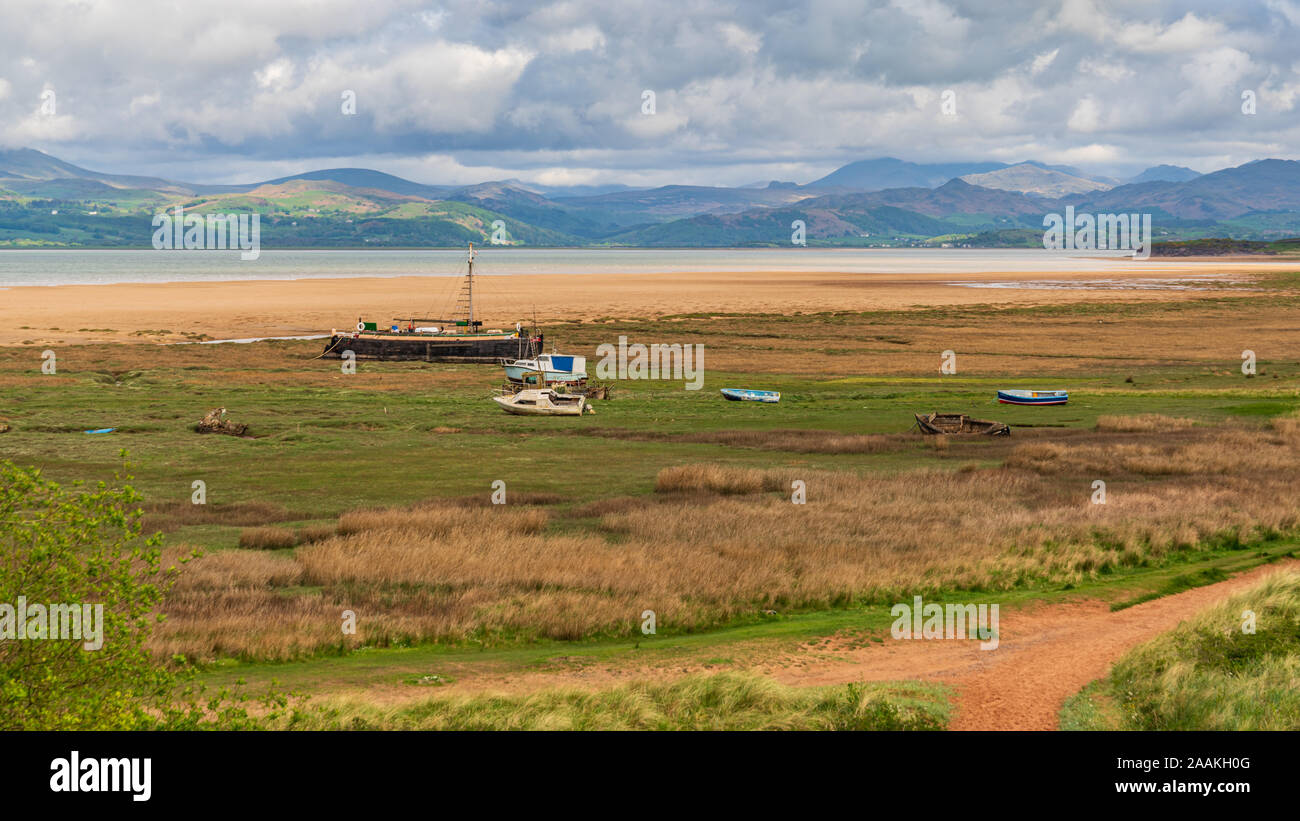 Boats in the grass, with clouds over the Lake District National Park in the background, seen in