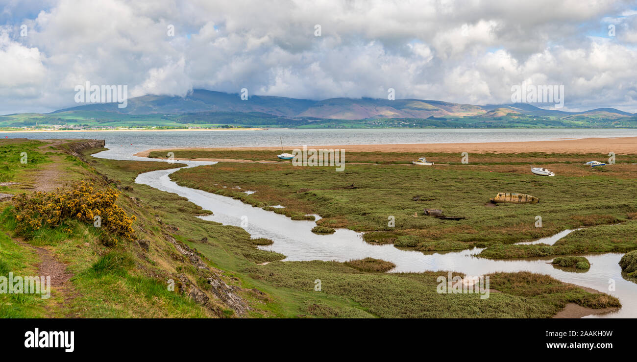 Boats in the grass, with clouds over the Lake District National Park in the background, seen in