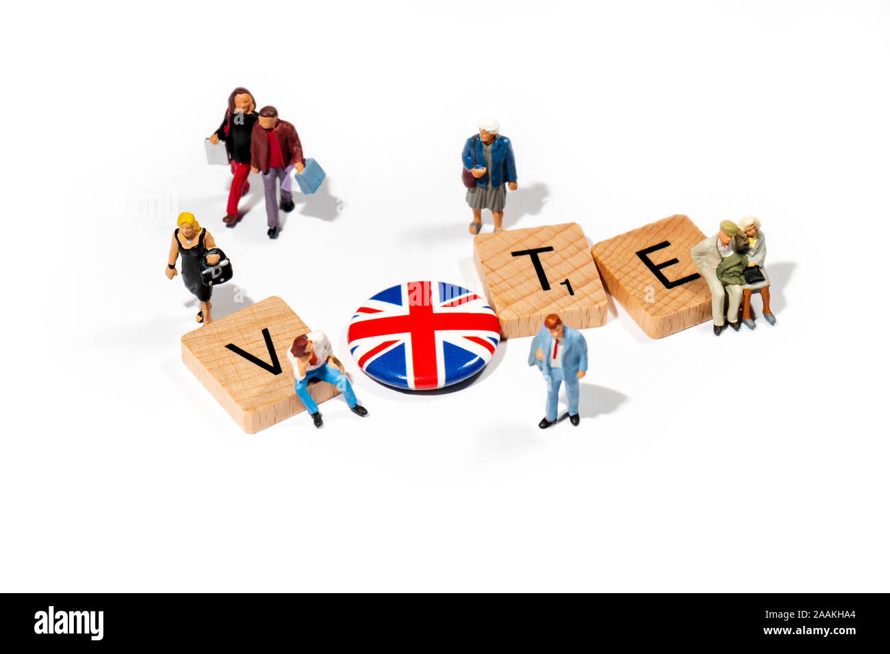 Conceptual: Scrabble letters spell out VOTE, accompanied by  model people figurines. Stock Photo