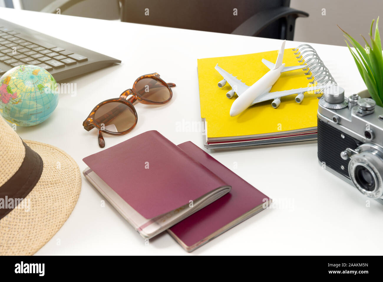 Travel planning concept at office with passports sunglases and computer. Stock Photo