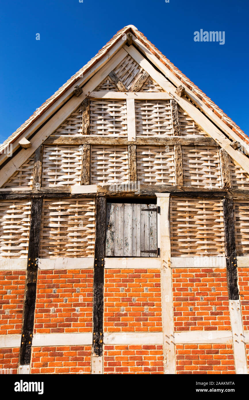 A beautiful old barn with upper walls woven from split timber on a farm in Great Comberton, Vale of Evesham, Worcestershire, UK. Building using tradit Stock Photo