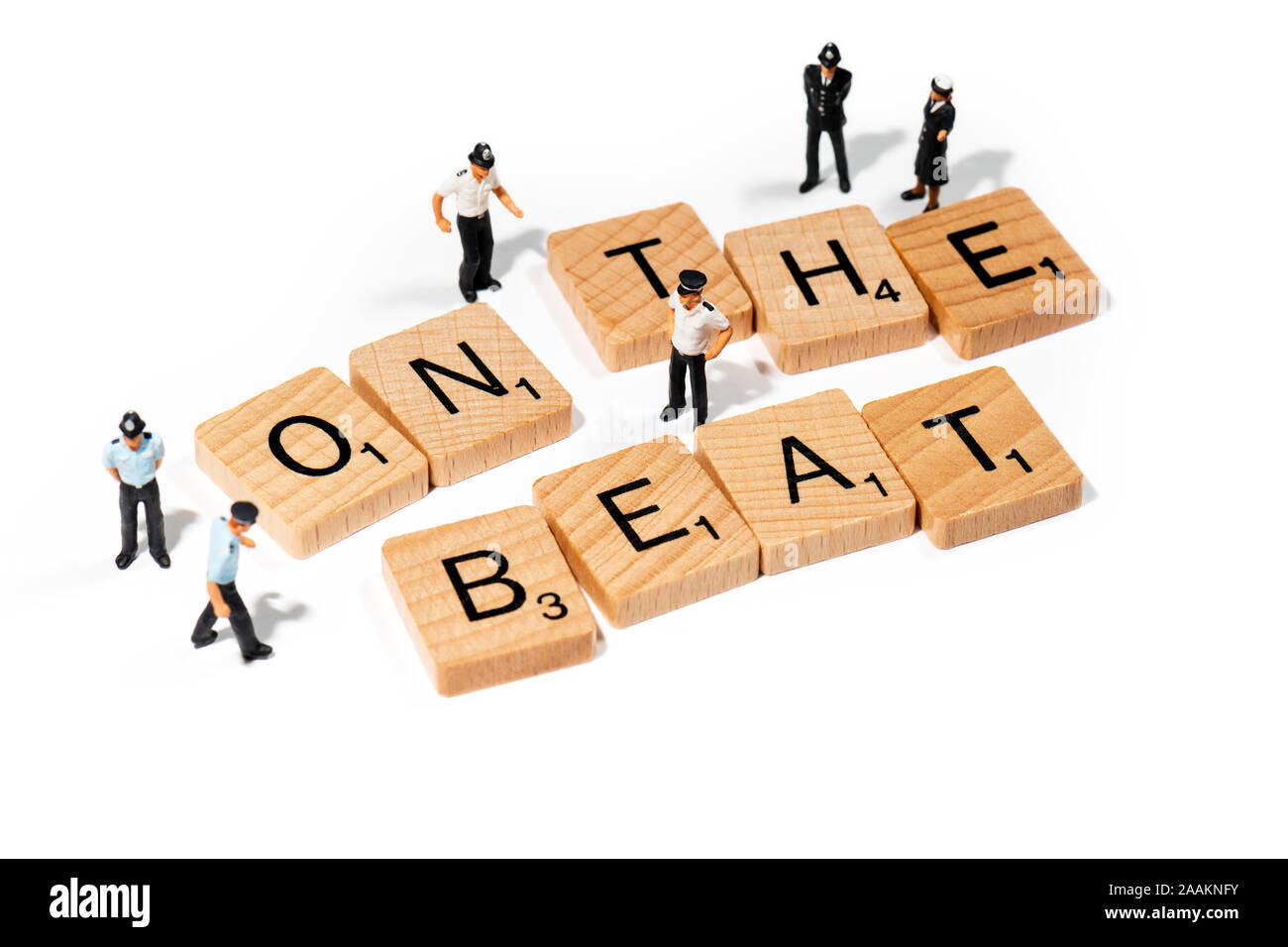 Conceptual: Scrabble letters spell out ON THE BEAT, accompanied by  model police officer figurines. Stock Photo