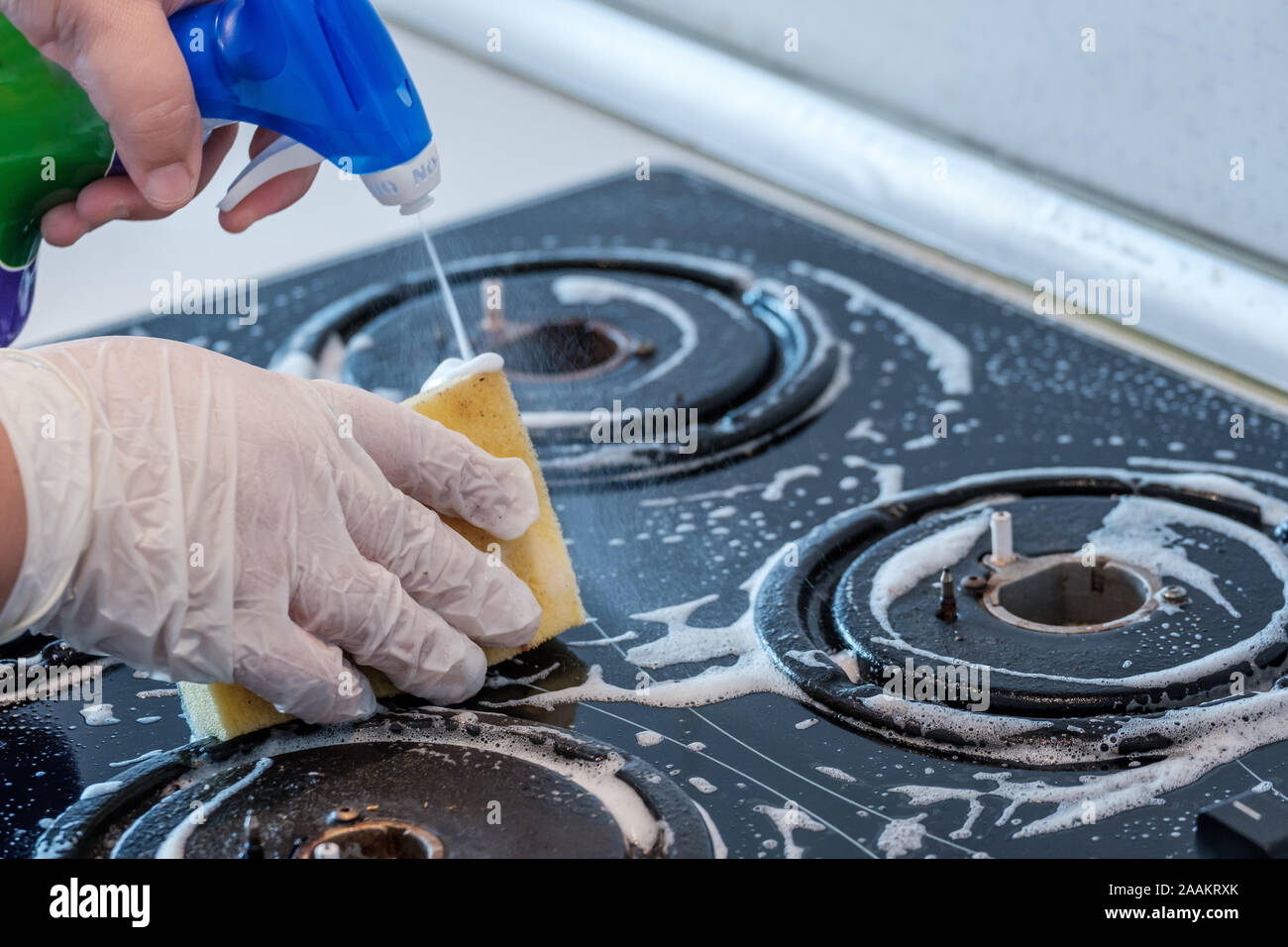 Cleaning a gas stove with kitchen utensils, household concepts, or