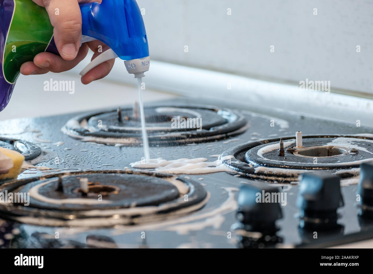 Cleaning a gas stove with kitchen utensils, household concepts, or