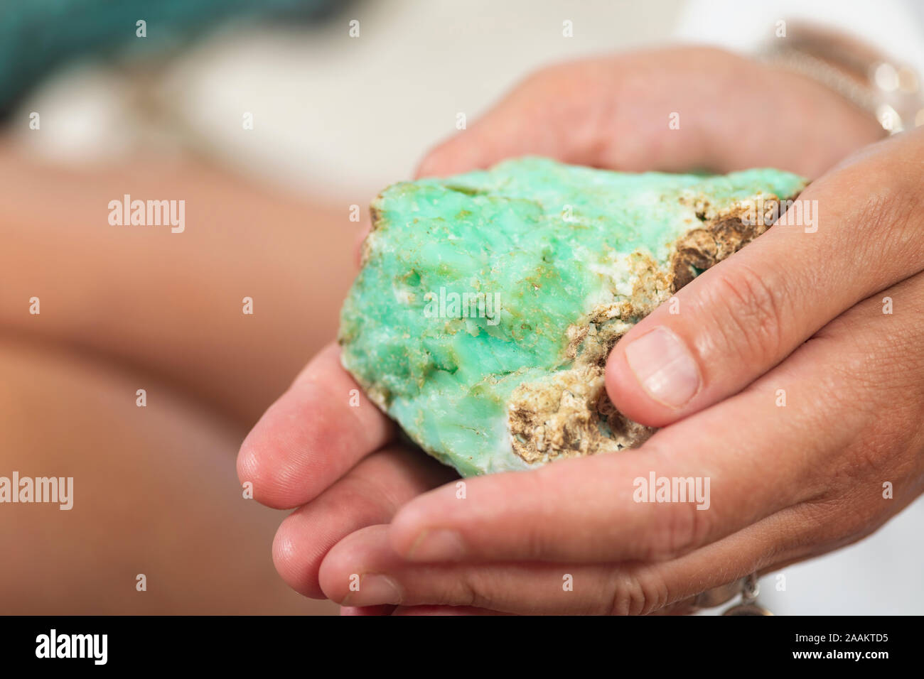 Female crystal healing therapist hand holding green chrysoprase crystal