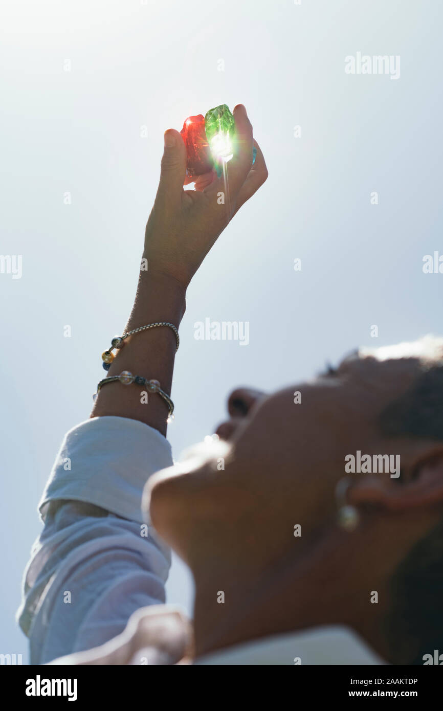 Female crystal healing therapist hand holding red and emerald green andara crystals. Cleansing