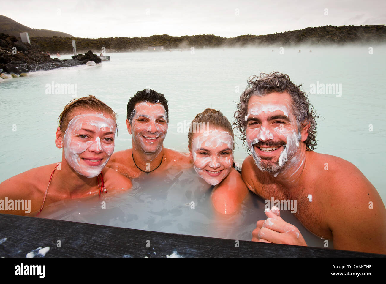 Friends relax at the Blue Lagoon which uses hot water from a geothermal power station near Keflavik in Iceland. Stock Photo