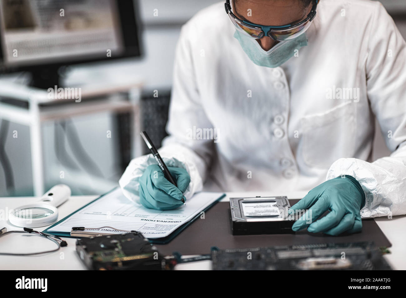 Forensic science investigator examining computer hard drive. Digital ...
