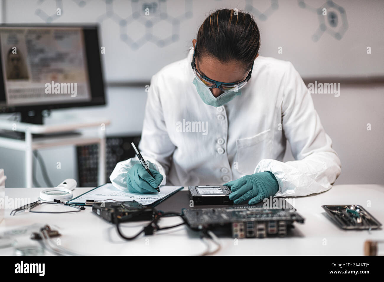 Forensic science investigator examining computer hard drive. Digital ...