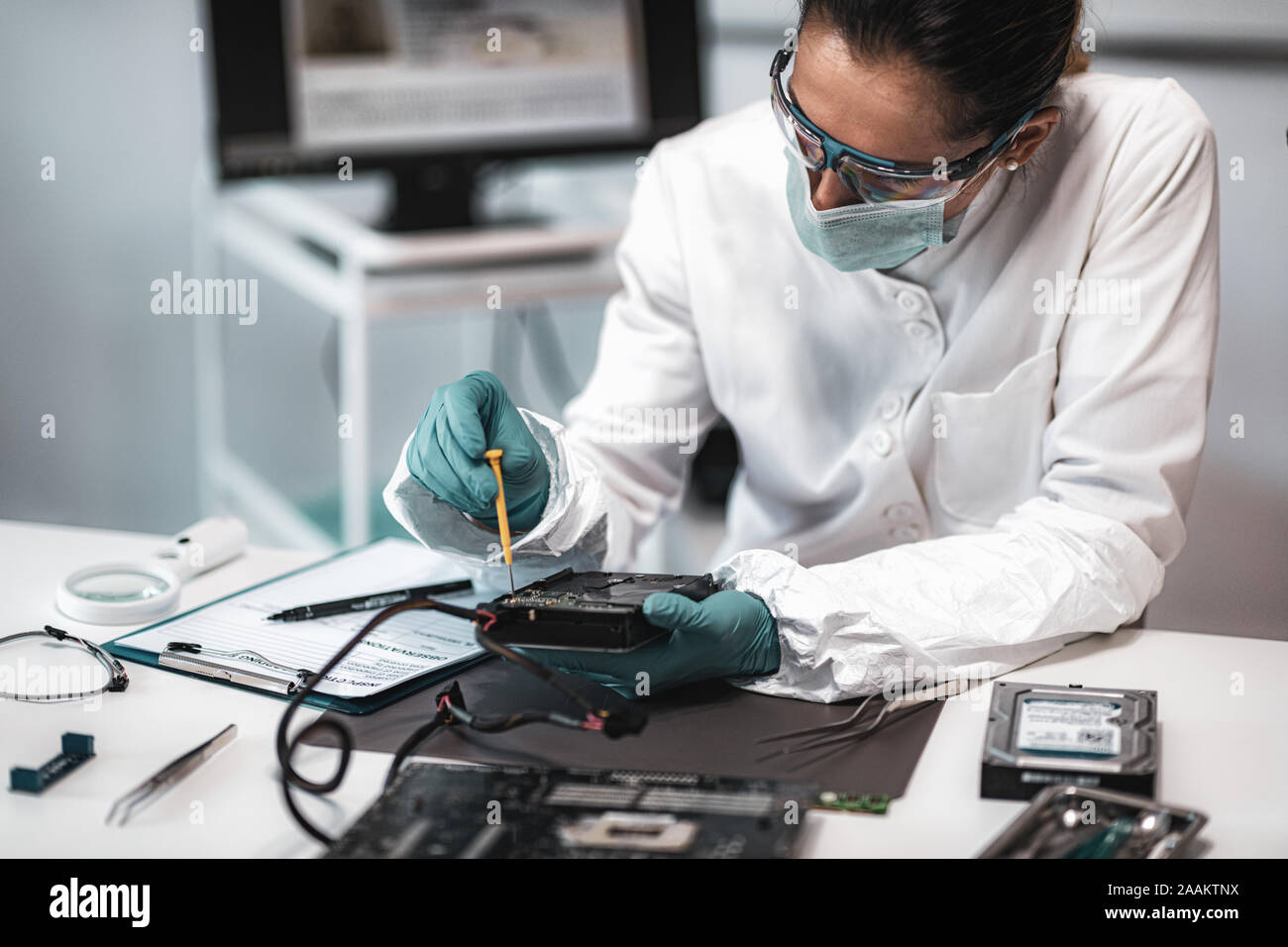 Forensic science investigator examining computer hard drive. Digital ...
