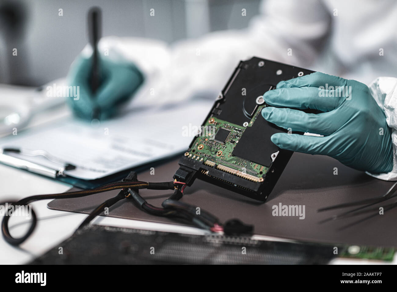 Forensic science investigator examining computer hard drive. Digital ...