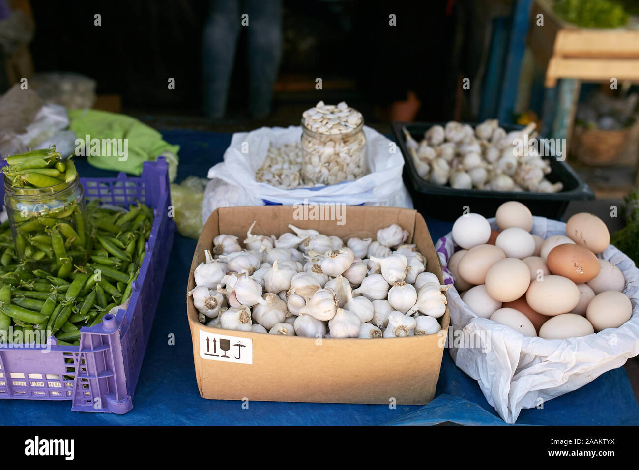 Display of fresh green and white onions, garlic, eggs, peas and pumpkin