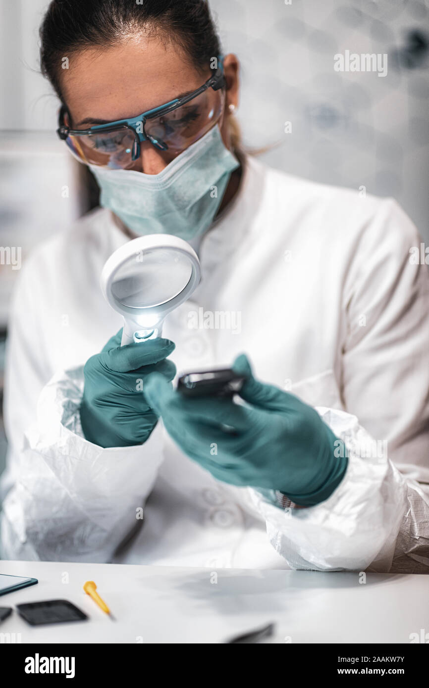 Digital forensic science. Police forensic analyst examining confiscated