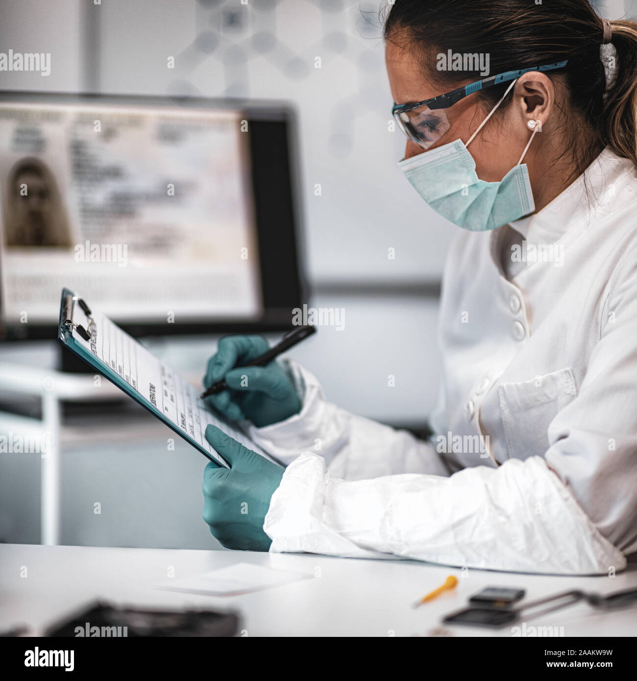Digital forensic science. Police forensic expert taking notes Stock
