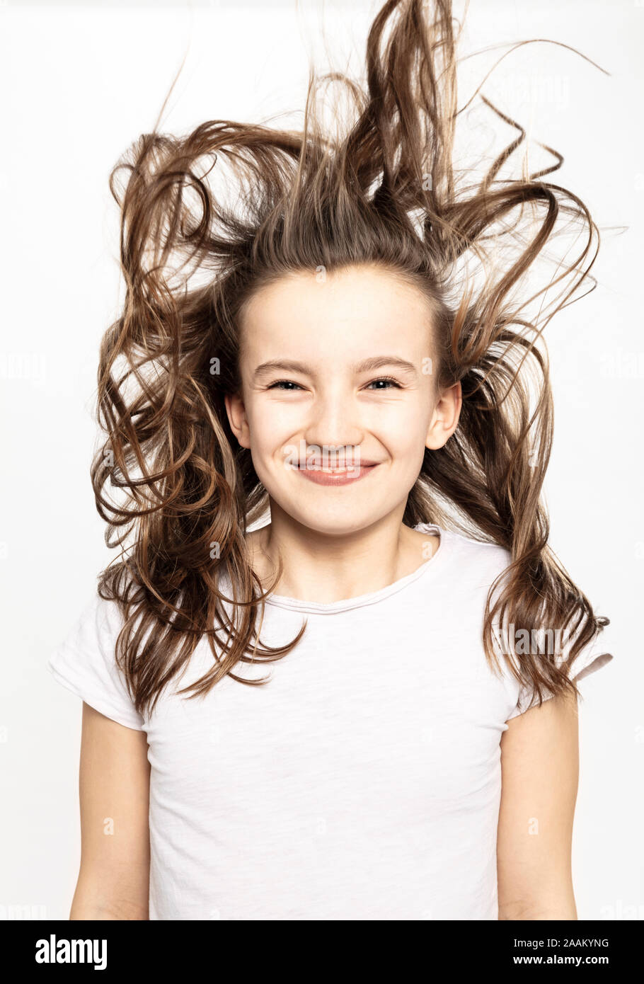 Happy girl with flying hair, white background Stock Photo