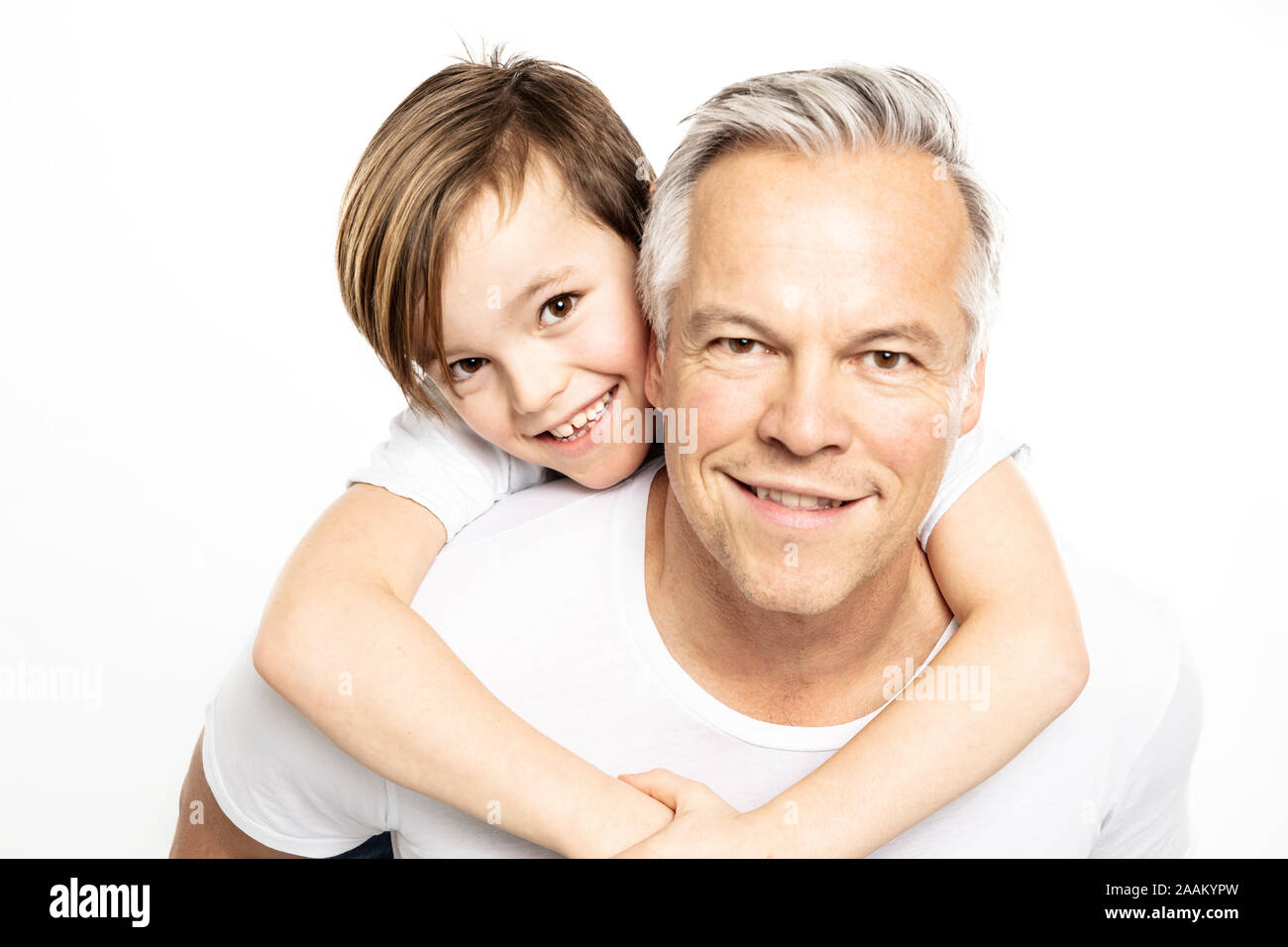 Father giving son piggyback ride, white background Stock Photo