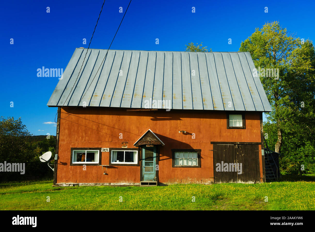 Old and crooked rural house with a metal roof, Island Pond, Vermont, USA. Stock Photo