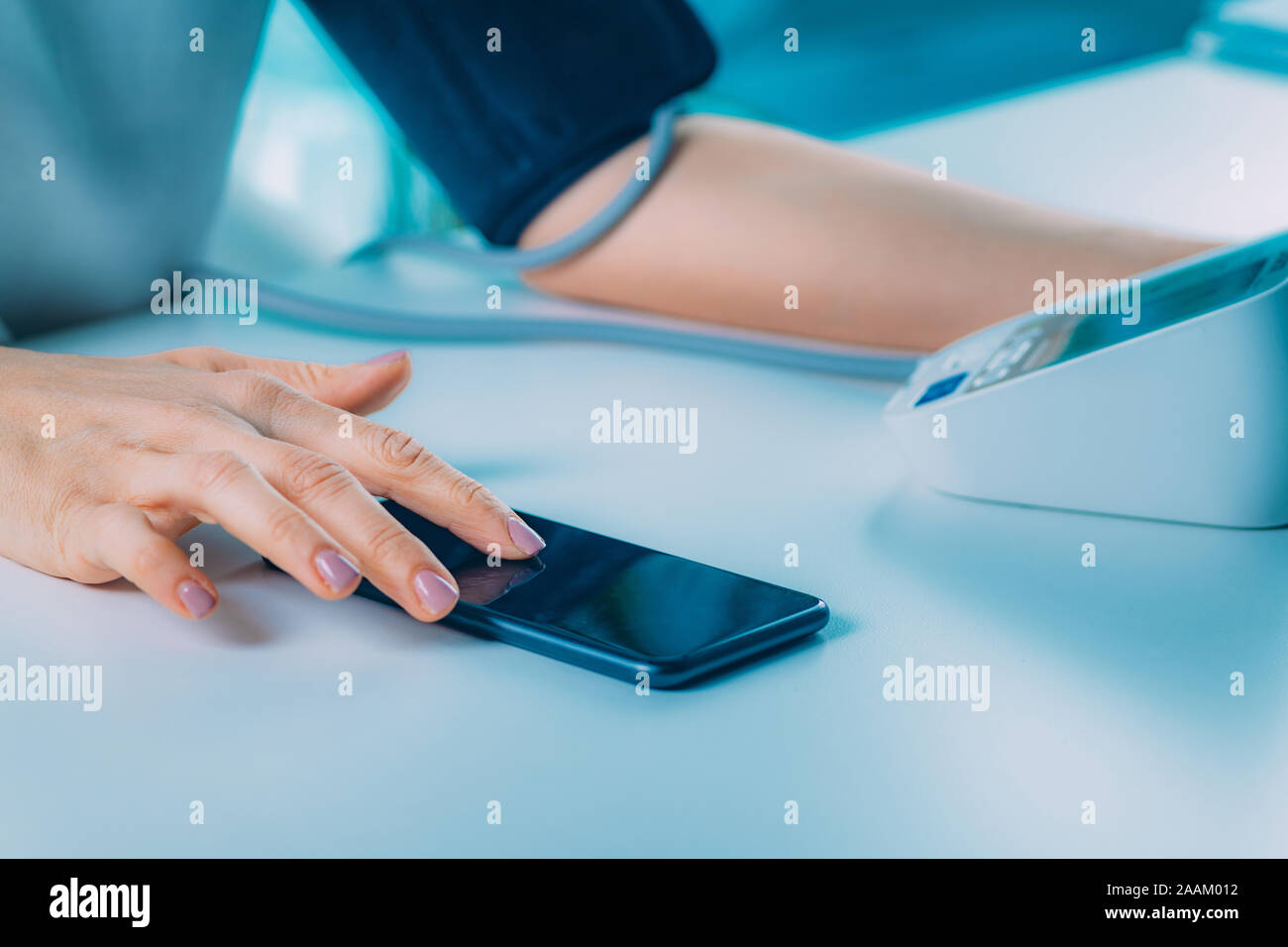 Measuring blood pressure and entering data in the smart phone. Stock Photo