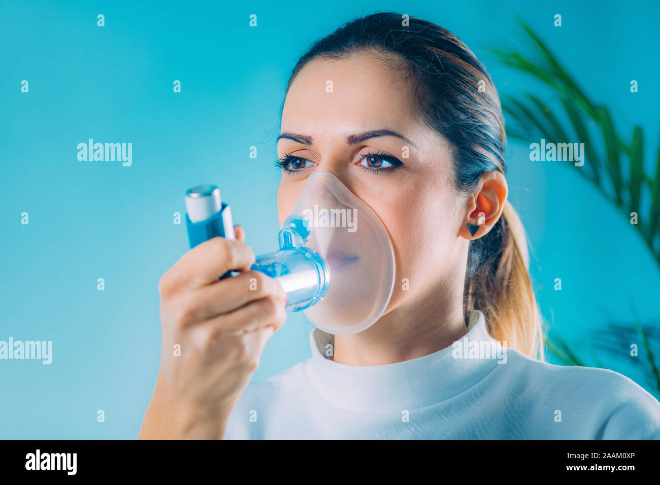 Woman using asthma inhaler with extension tube Stock Photo Alamy