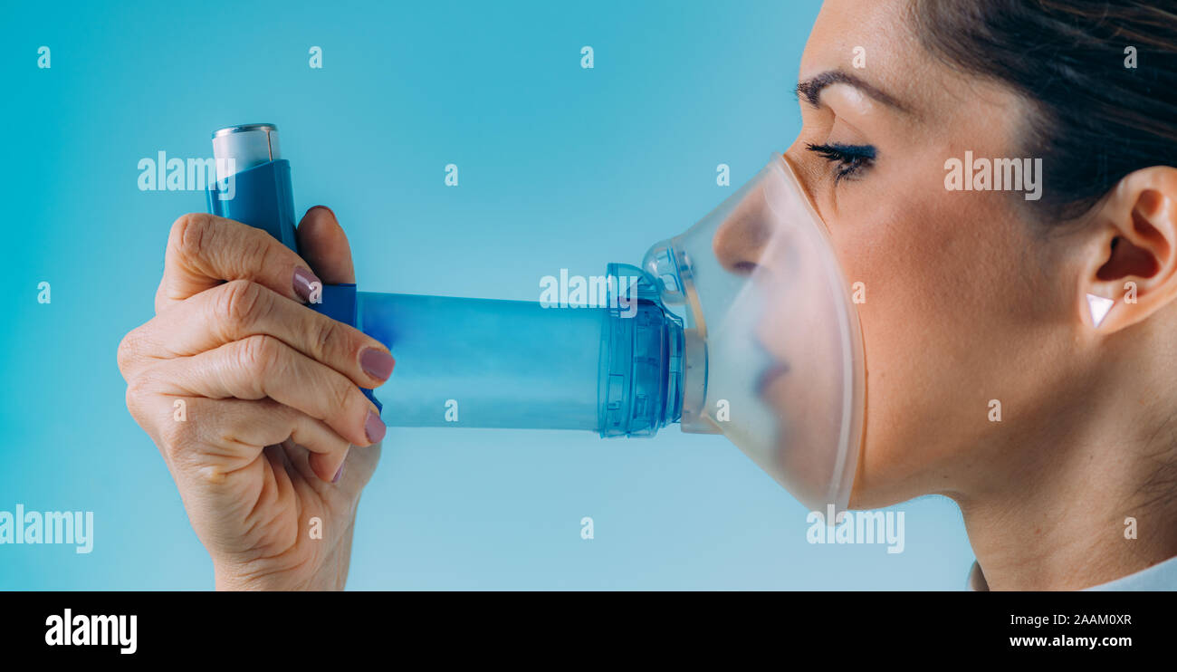 Woman using asthma inhaler with extension tube Stock Photo Alamy