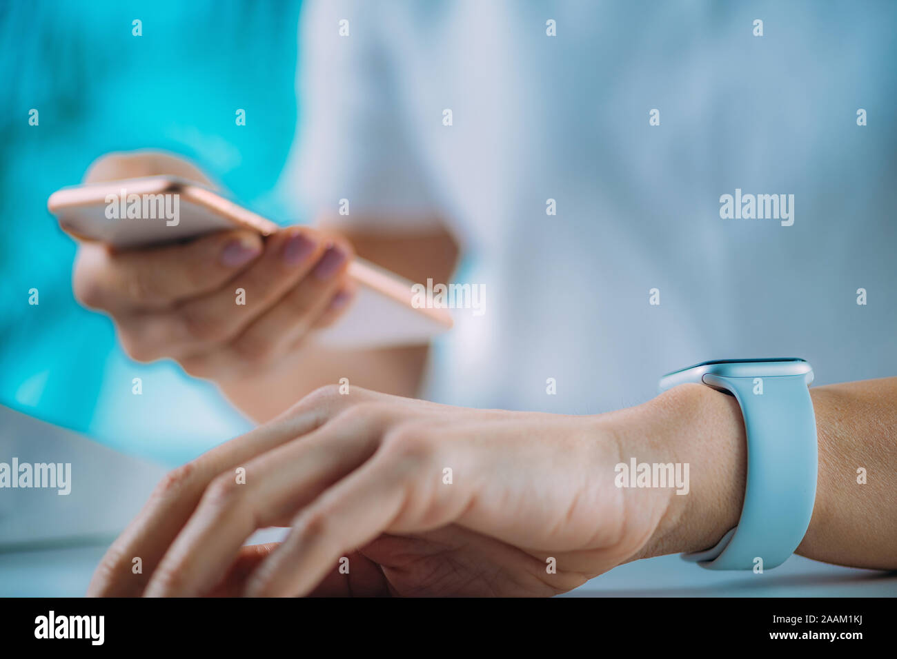 Woman measuring heart rate, using smart phone and smart watch. Stock Photo