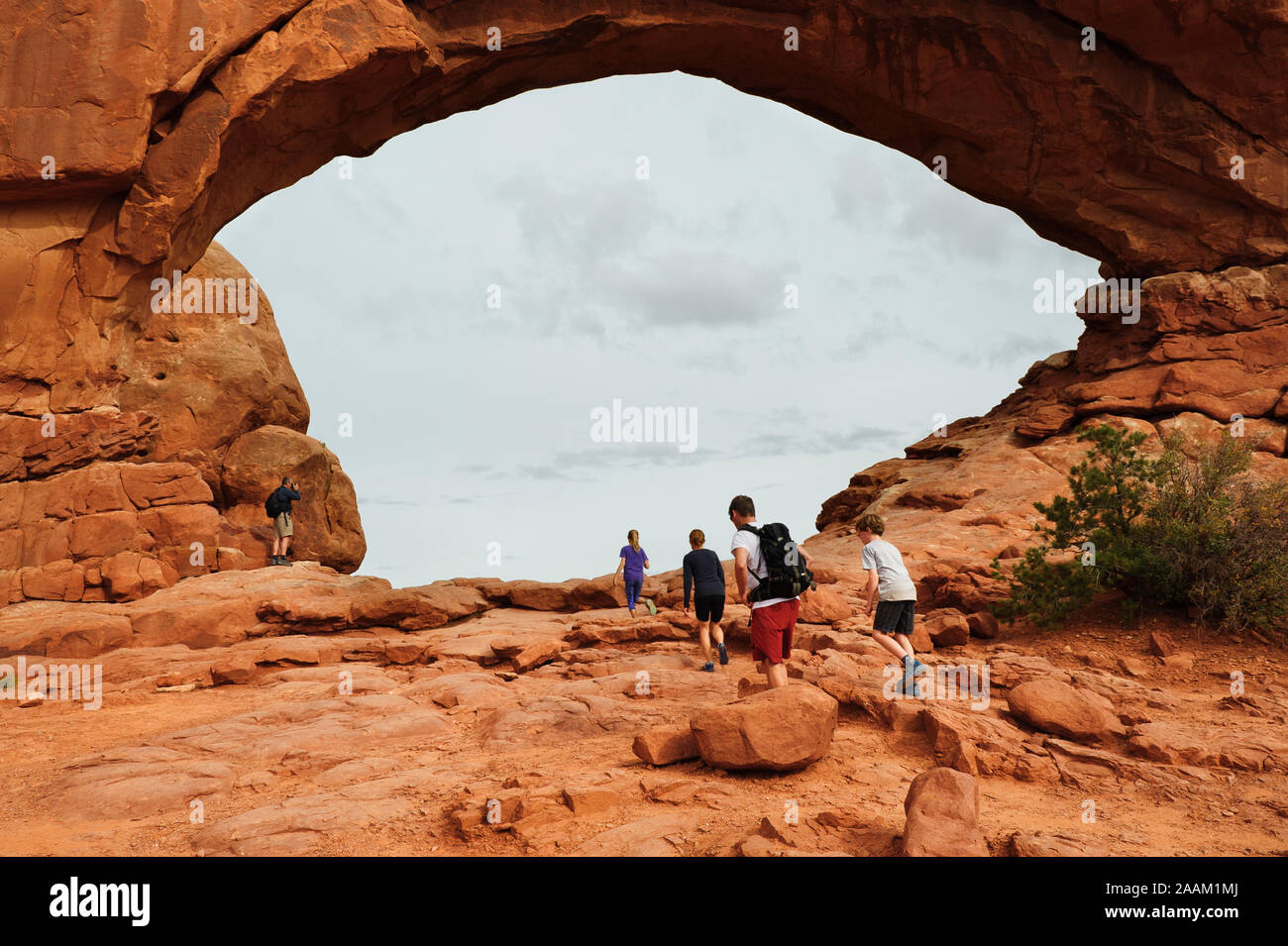 Visitors walking towards the North Window Arch at Arches National Park near Moab, Utah, USA. Stock Photo