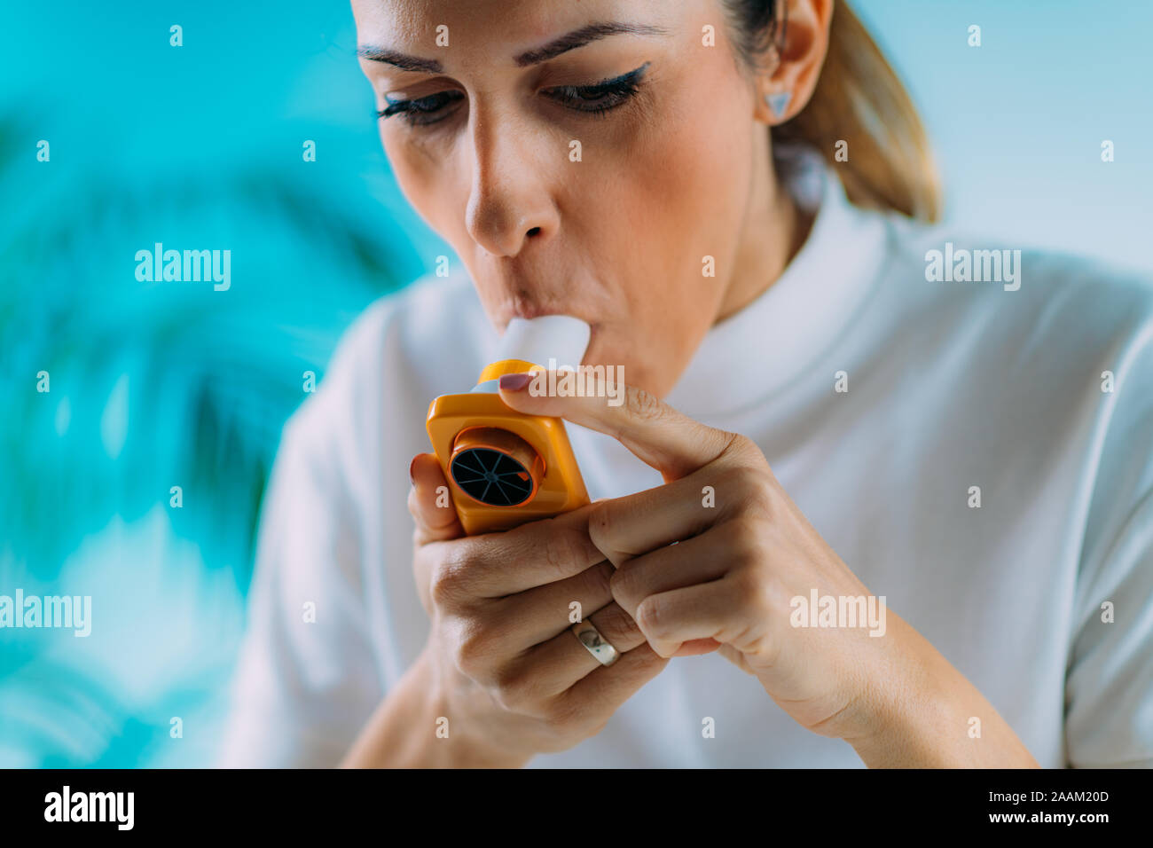 Woman using spirometer, measuring lung capacity and force expiratory