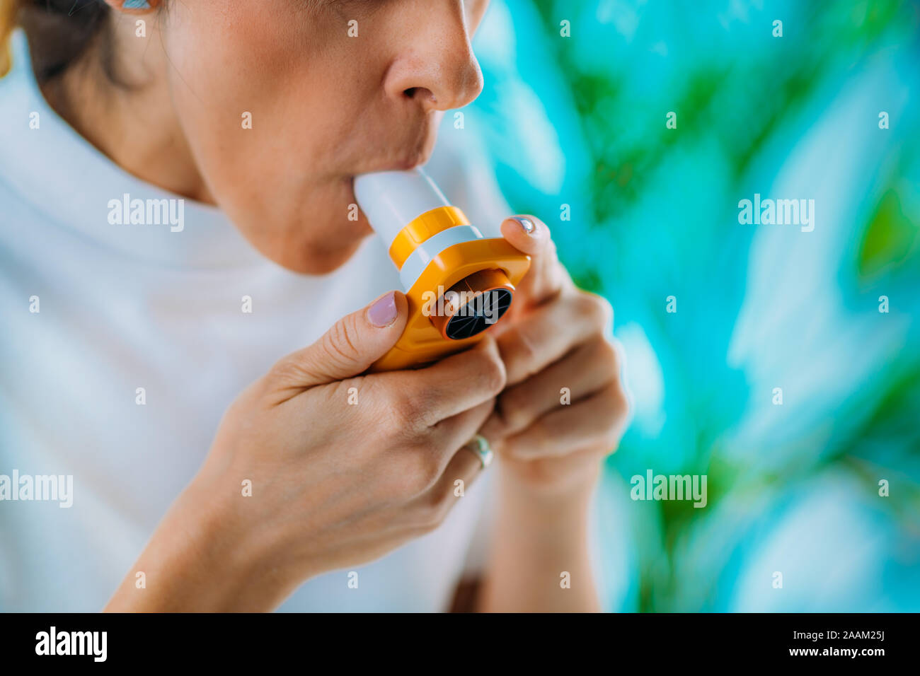 Woman using spirometer, measuring lung capacity and force expiratory