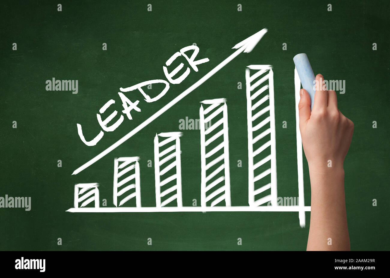 Hand drawing LEADER inscription with white chalk on blackboard ...