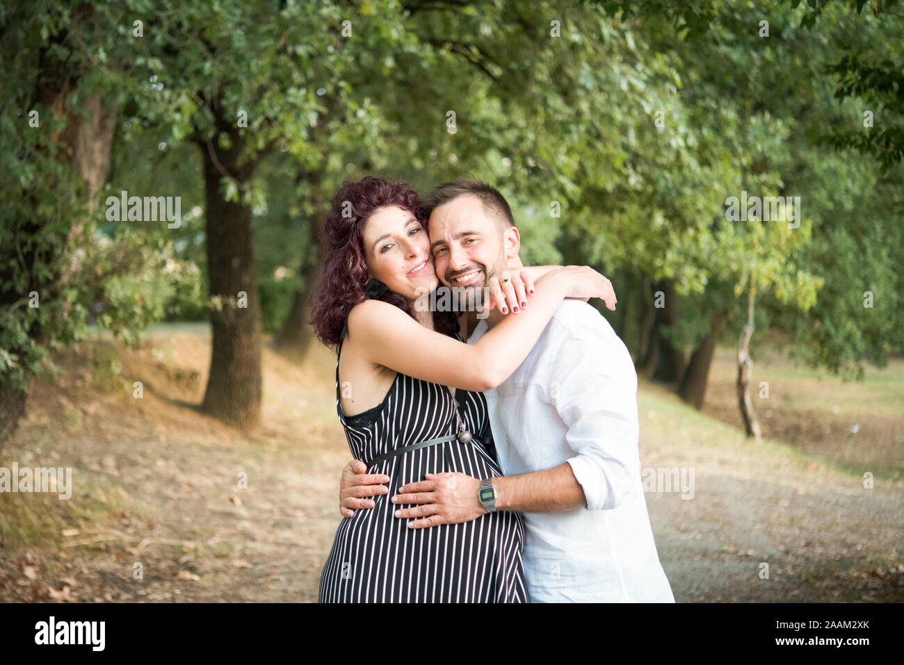 Couple hugging in park Stock Photo - Alamy