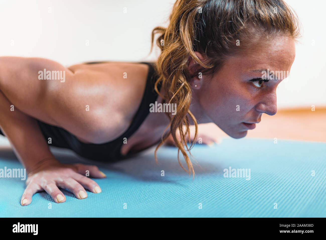 Doing push-ups. Woman doing HIIT or high intensity interval training exercises. Stock Photo