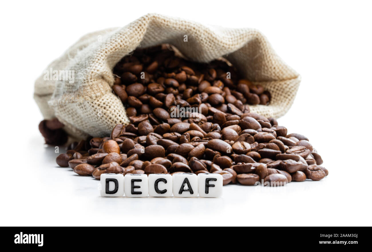 Roasted coffee beans scattered out of the bag. Concept of decaf coffee