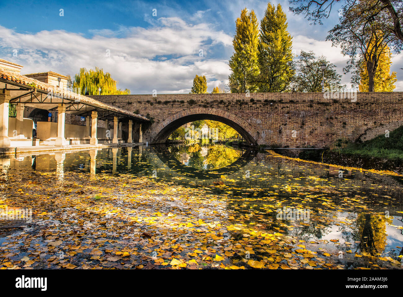 Bevagna, Perugia, Umbria, center of Italy. The river Topino that surrounds the outer walls of the city with autumn colors and the reflections. Stock Photo