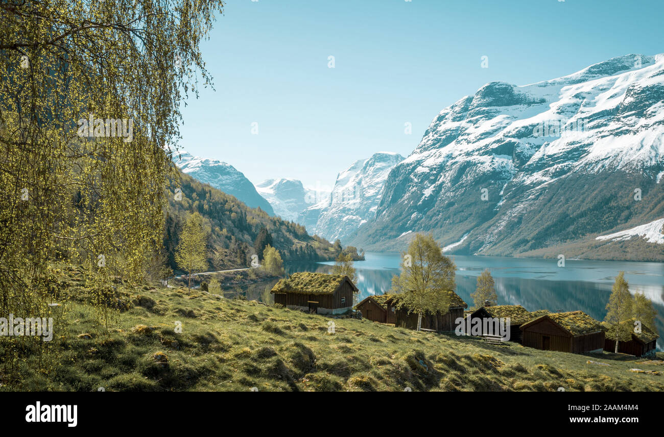 Beautiful norwegian landscape with old farm, lake and mountains Stock Photo